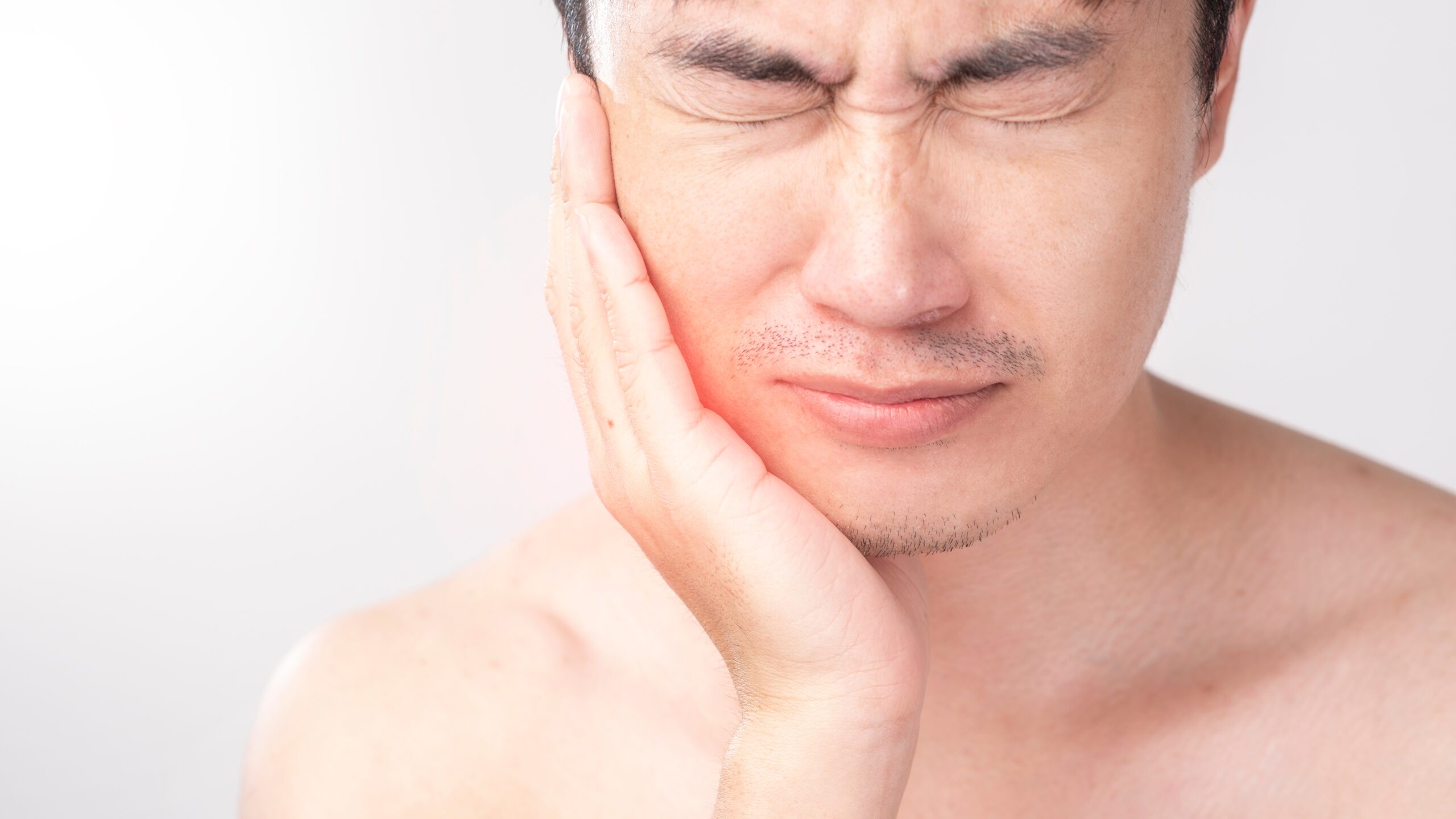 A man with his hand on his face.