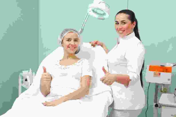 A woman is getting her hair cut by an esthetician.