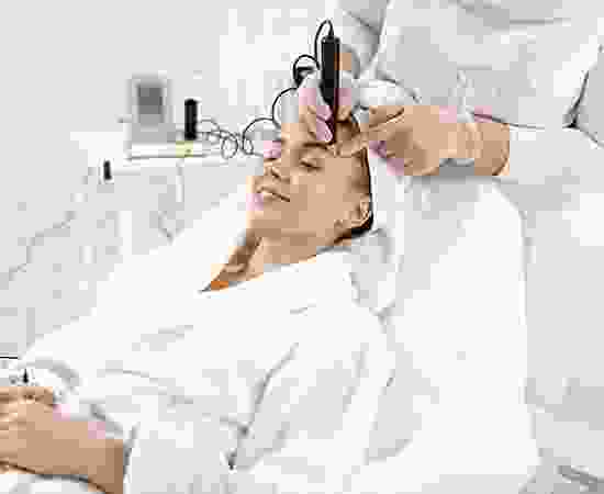 A woman is getting her hair cut by an esthetician.