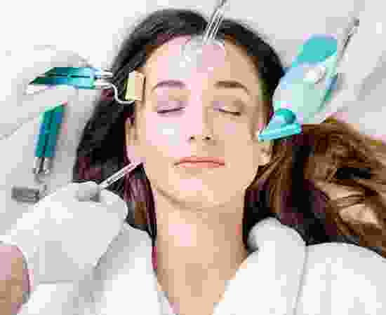 A woman getting her face waxed by two hands.