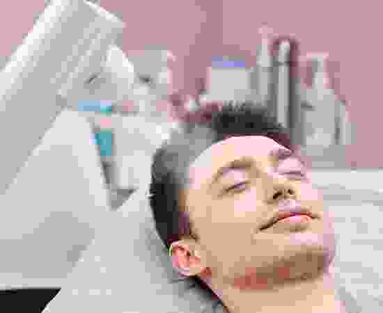 A man with his eyes closed in the middle of a procedure.