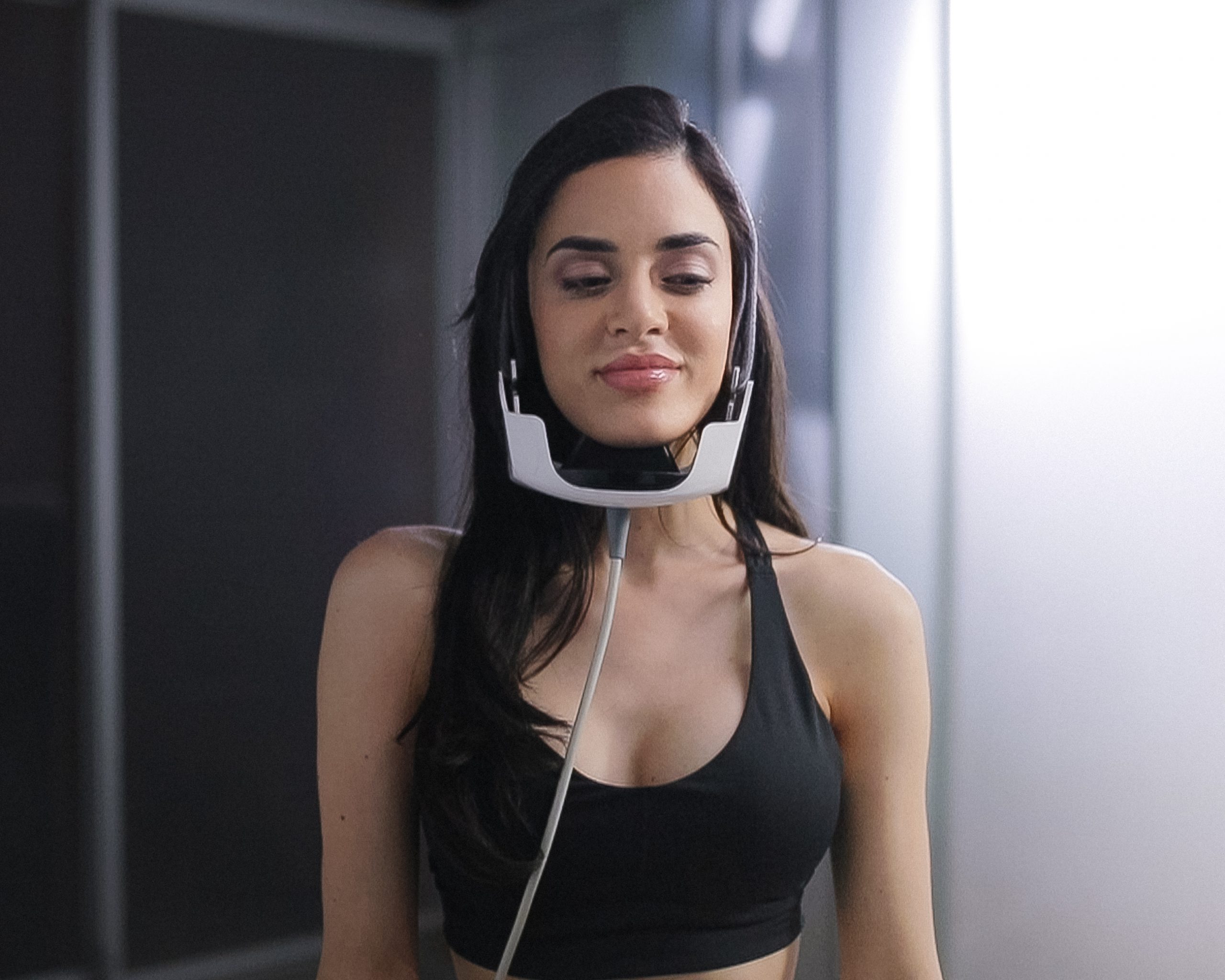 A woman with her eyes closed and headphones around her neck.