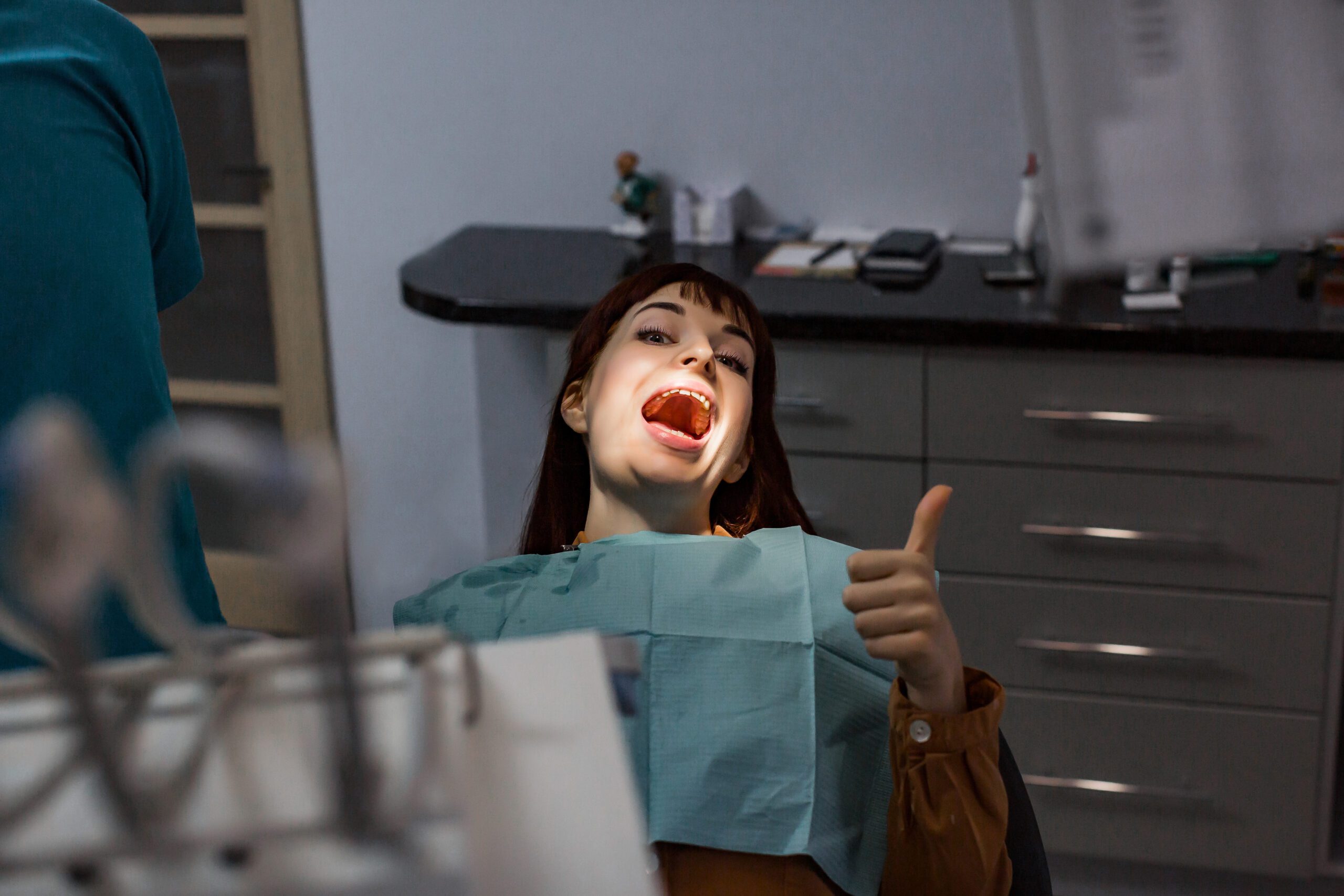 A woman with her mouth open giving the thumbs up.